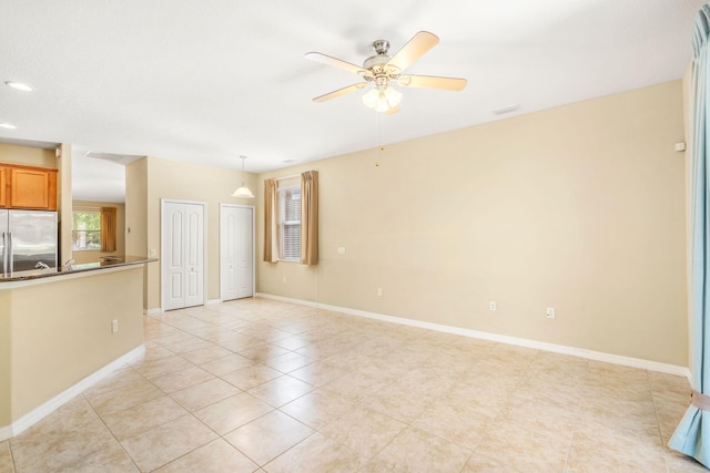 unfurnished living room with ceiling fan and light tile flooring