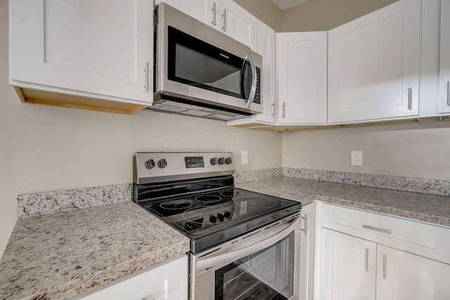 kitchen featuring white cabinets, light stone counters, and stainless steel appliances