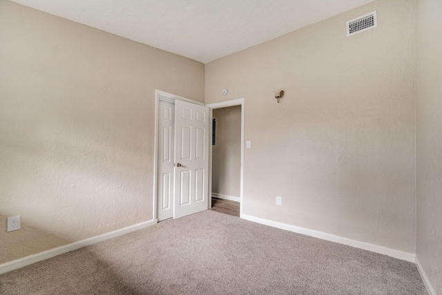 unfurnished room featuring dark colored carpet