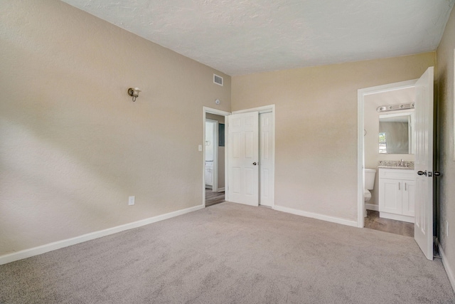 unfurnished bedroom with connected bathroom, light colored carpet, and sink