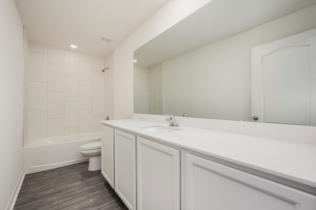 full bathroom featuring toilet, tiled shower / bath, vanity, and wood-type flooring