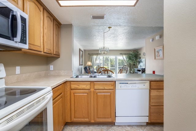 kitchen featuring light tile flooring, white appliances, an inviting chandelier, sink, and a textured ceiling