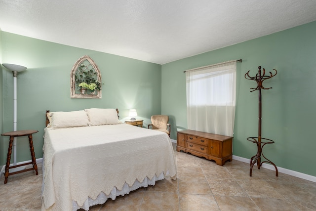 bedroom featuring a textured ceiling and light tile flooring