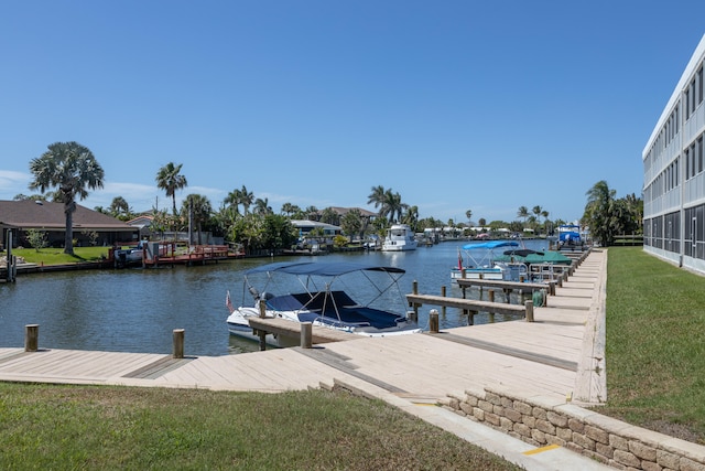 view of dock featuring a lawn and a water view