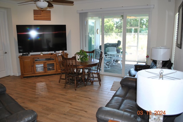 living room with hardwood / wood-style floors, crown molding, and ceiling fan