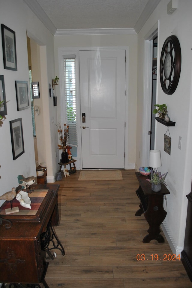 foyer entrance with dark hardwood / wood-style floors and crown molding