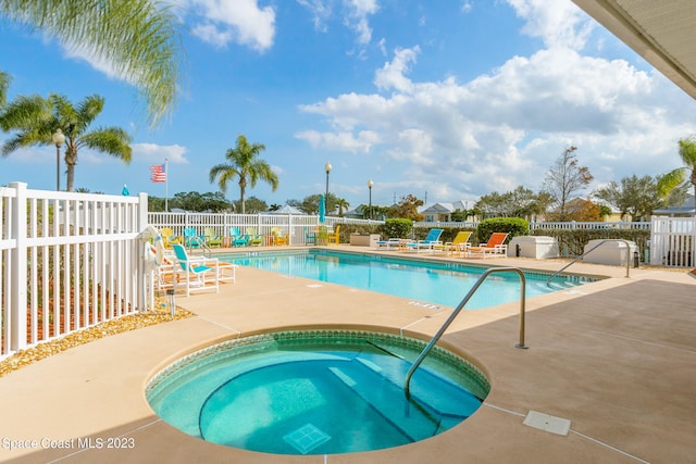 view of swimming pool featuring a community hot tub and a patio