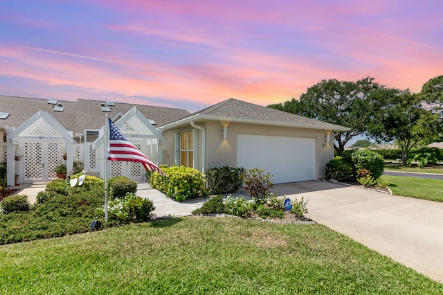 view of front of home with a garage and a yard