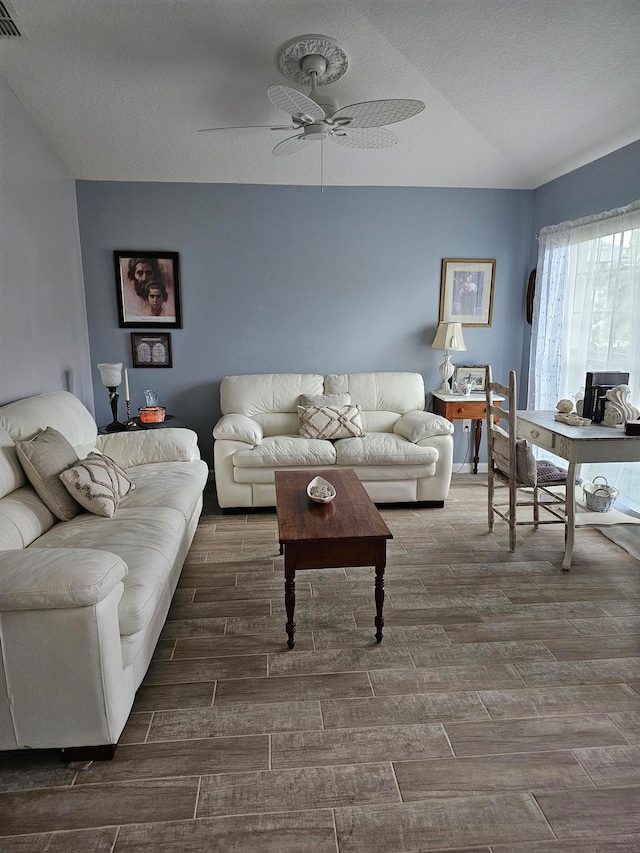 living room featuring a textured ceiling and ceiling fan