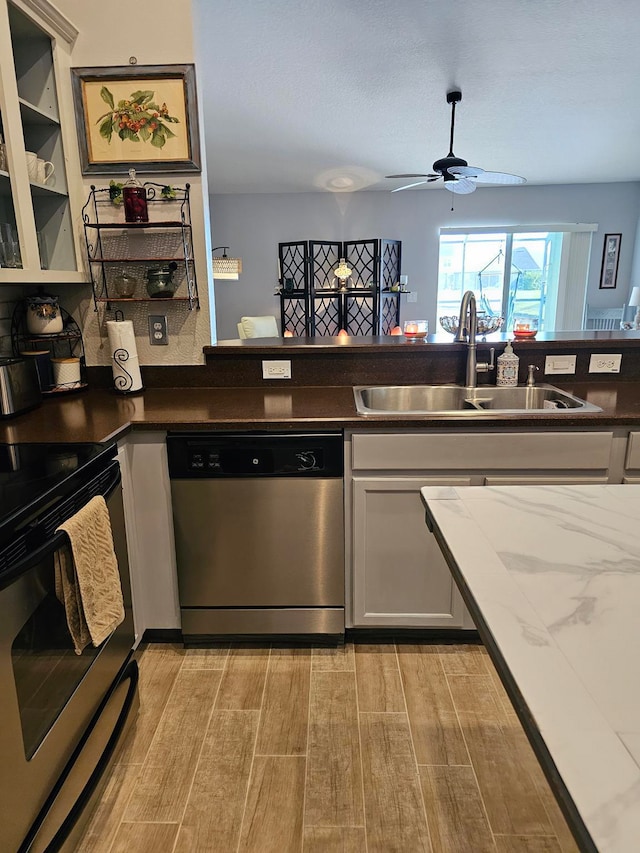 kitchen with electric stove, sink, ceiling fan, stainless steel dishwasher, and light wood-type flooring