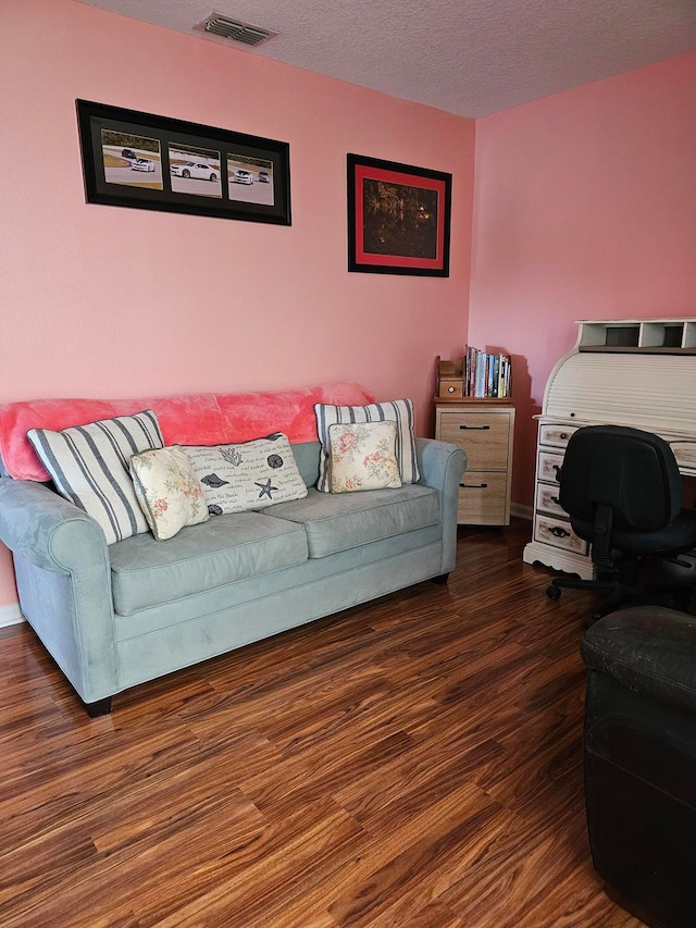 living room with dark hardwood / wood-style floors and a textured ceiling