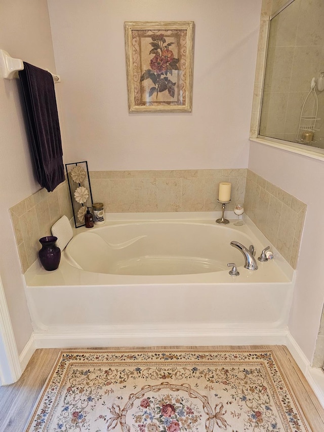 bathroom with a bath and wood-type flooring