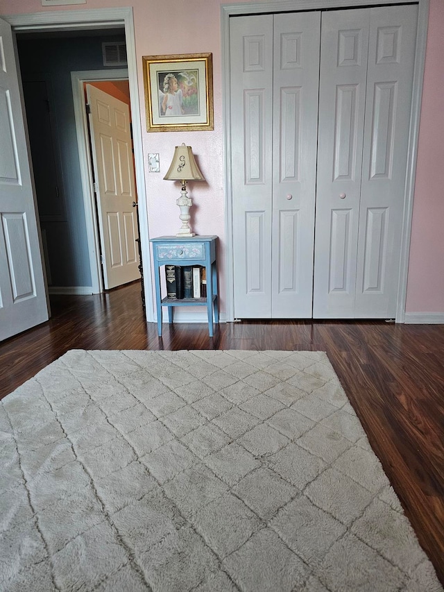 unfurnished bedroom featuring dark hardwood / wood-style floors and a closet