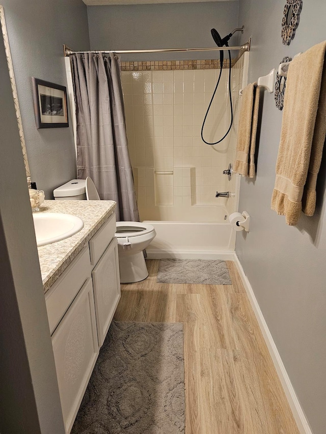 full bathroom featuring toilet, wood-type flooring, shower / tub combo with curtain, and vanity