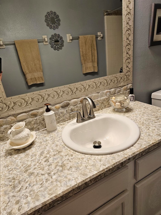 bathroom with backsplash, large vanity, and toilet