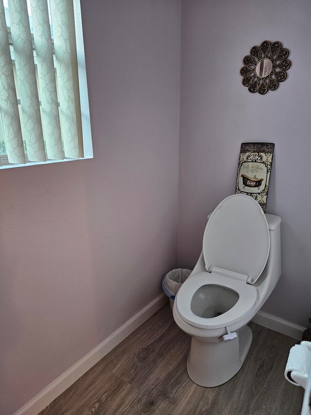 bathroom featuring toilet and wood-type flooring