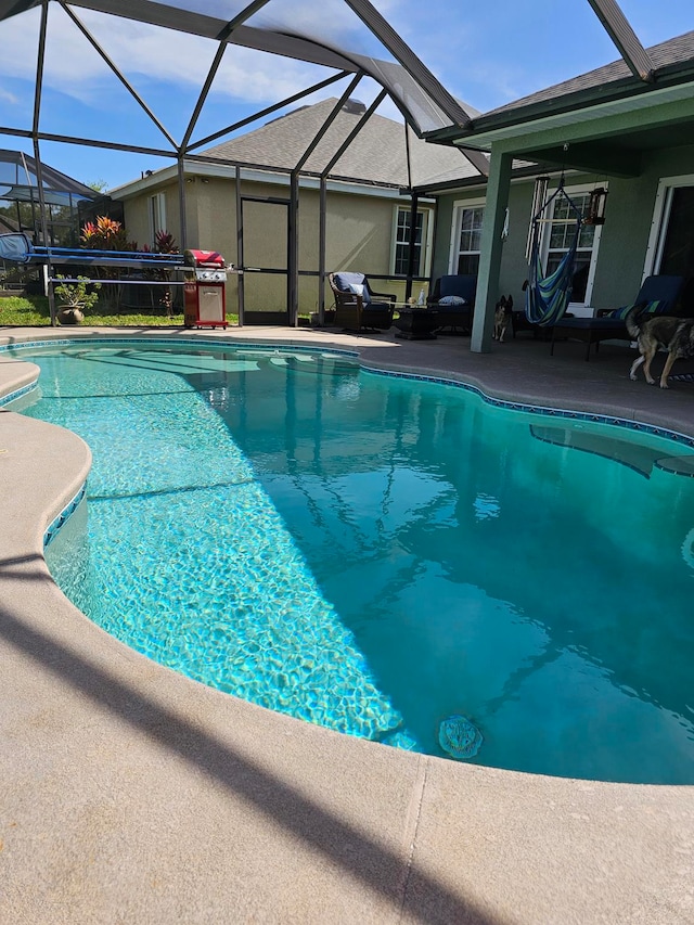 view of pool with an outdoor living space, a patio, and a lanai