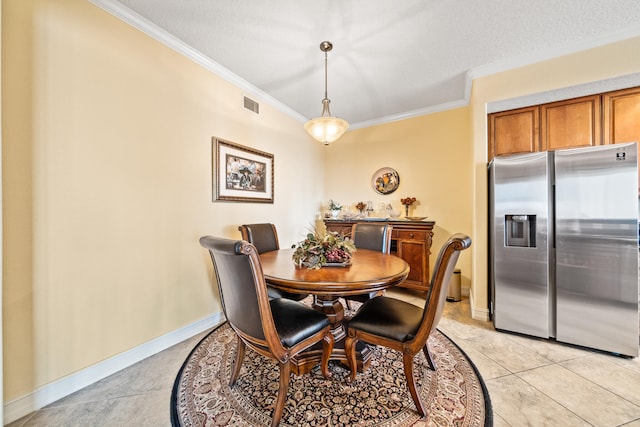 dining room with crown molding, a textured ceiling, and light tile floors