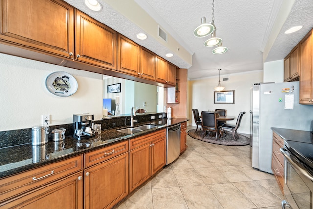 kitchen featuring light tile floors, sink, pendant lighting, a textured ceiling, and dark stone counters