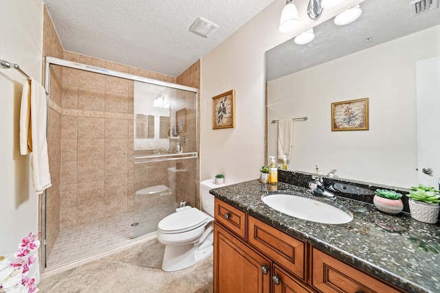 bathroom featuring toilet, a textured ceiling, tile flooring, oversized vanity, and an enclosed shower