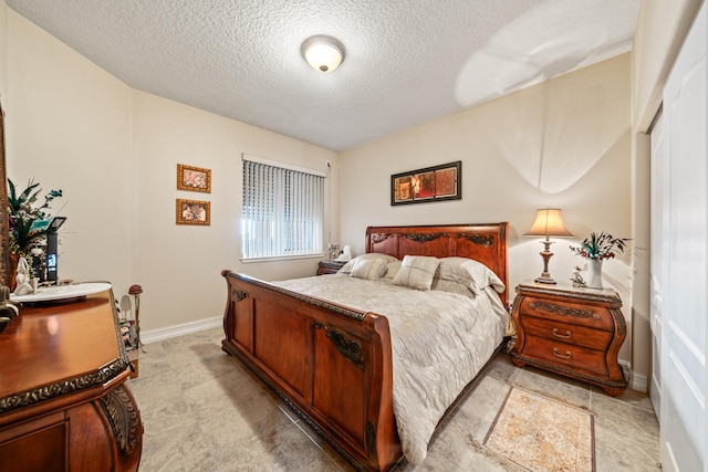 bedroom with a textured ceiling and light tile floors