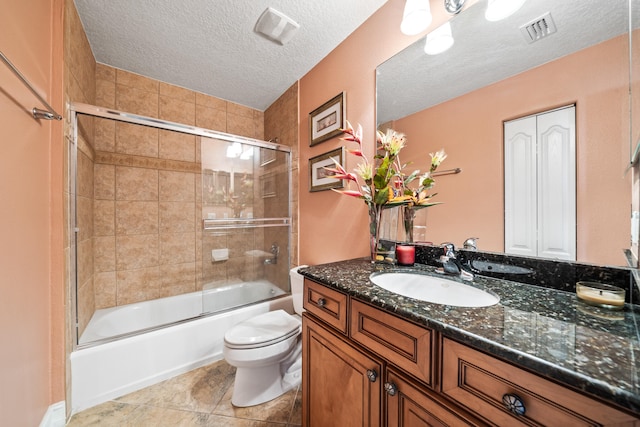 full bathroom featuring toilet, a textured ceiling, tile floors, combined bath / shower with glass door, and vanity