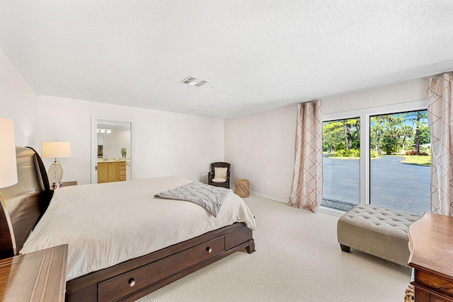 carpeted bedroom featuring access to outside, a textured ceiling, and ensuite bathroom