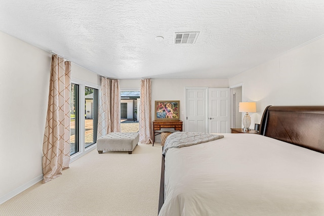 carpeted bedroom featuring a textured ceiling and access to outside