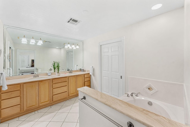 bathroom featuring tile floors, vanity with extensive cabinet space, a bath, and dual sinks