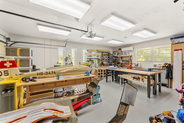 garage with a wall mounted AC, a workshop area, and a garage door opener