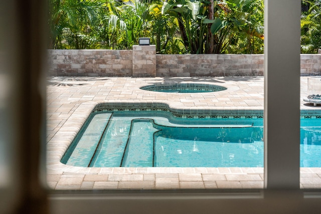 view of swimming pool with an in ground hot tub