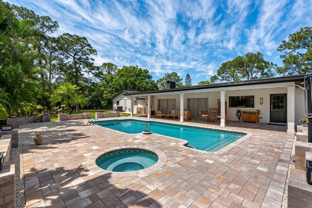 view of swimming pool featuring an in ground hot tub and a patio