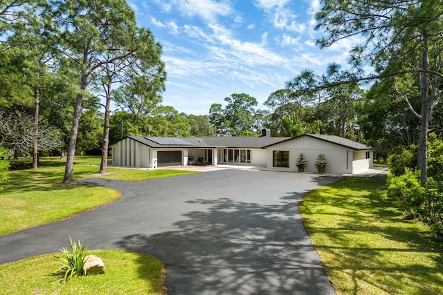 ranch-style house featuring a front yard and a garage