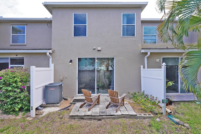 back of property with central AC and a patio area