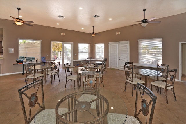 dining space featuring light tile patterned flooring, lofted ceiling, and a healthy amount of sunlight