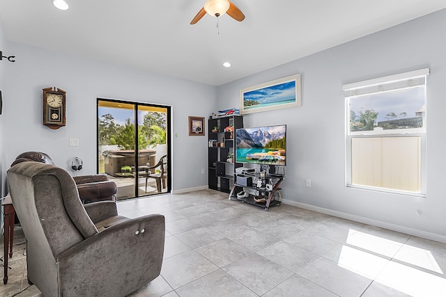 living area featuring light tile floors and ceiling fan