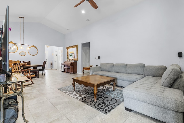 living room featuring high vaulted ceiling, ceiling fan with notable chandelier, and light tile flooring