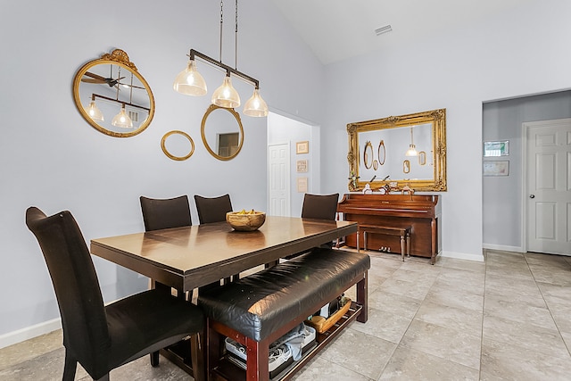 tiled dining area featuring high vaulted ceiling