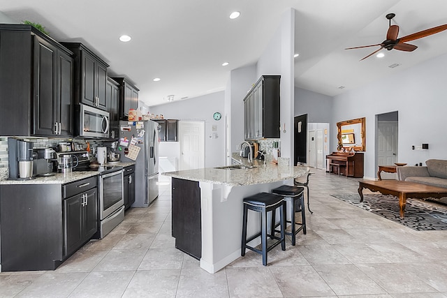 kitchen featuring ceiling fan, light tile floors, sink, stainless steel appliances, and tasteful backsplash