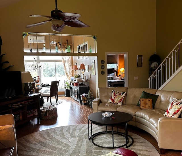 living room featuring hardwood / wood-style flooring and ceiling fan with notable chandelier