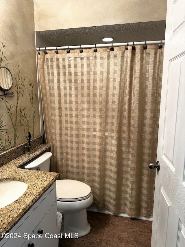 bathroom featuring vanity, curtained shower, and toilet