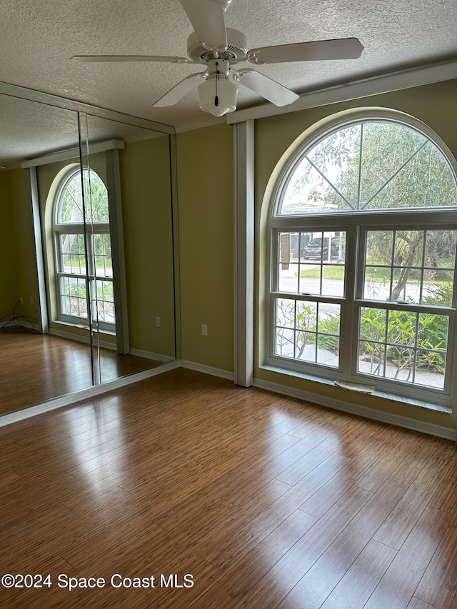 empty room with hardwood / wood-style floors and a textured ceiling