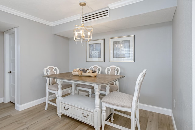 dining room with an inviting chandelier, ornamental molding, and light wood-type flooring