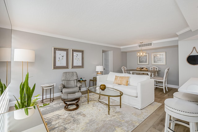 living room with an inviting chandelier, crown molding, and wood-type flooring