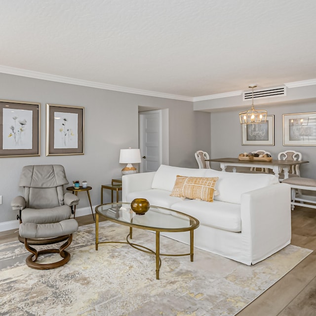 living room featuring ornamental molding, hardwood / wood-style floors, and a notable chandelier