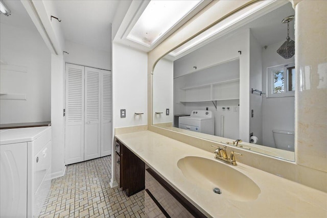 bathroom with oversized vanity, toilet, washing machine and dryer, and tile flooring