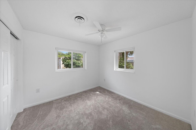 spare room with carpet flooring, a healthy amount of sunlight, and ceiling fan