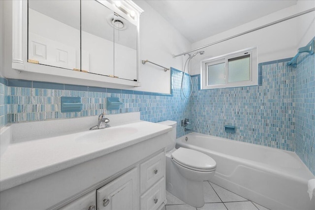 full bathroom featuring toilet, large vanity, tiled shower / bath combo, tile walls, and tile floors