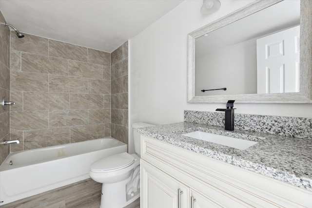 full bathroom with tiled shower / bath, toilet, vanity, and wood-type flooring