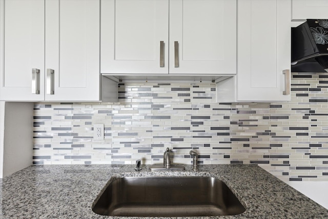 kitchen with backsplash, sink, white cabinets, and dark stone counters